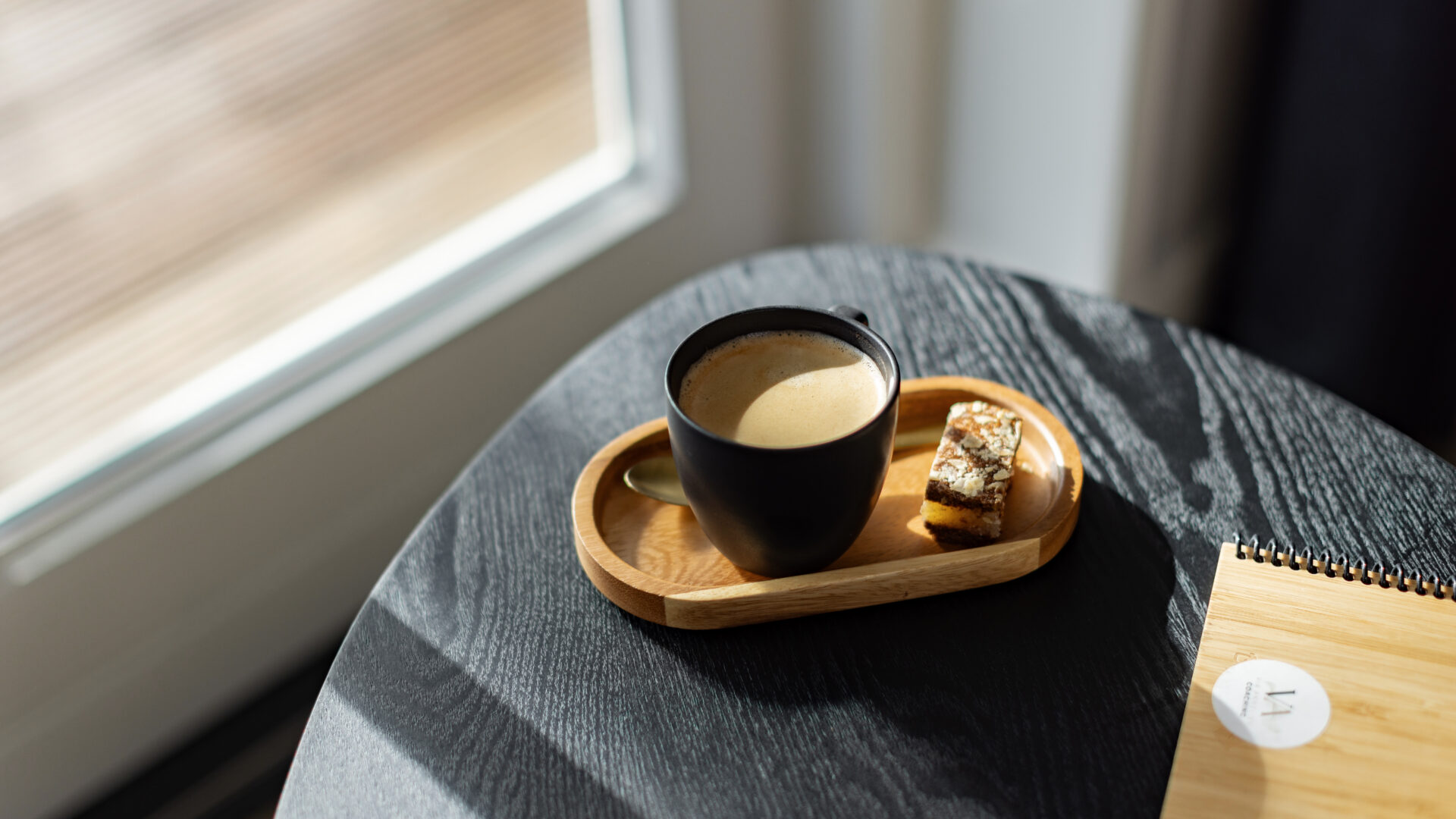 Kop koffie met lekkernij op een bijzettafel in een lichte coachingruimte.