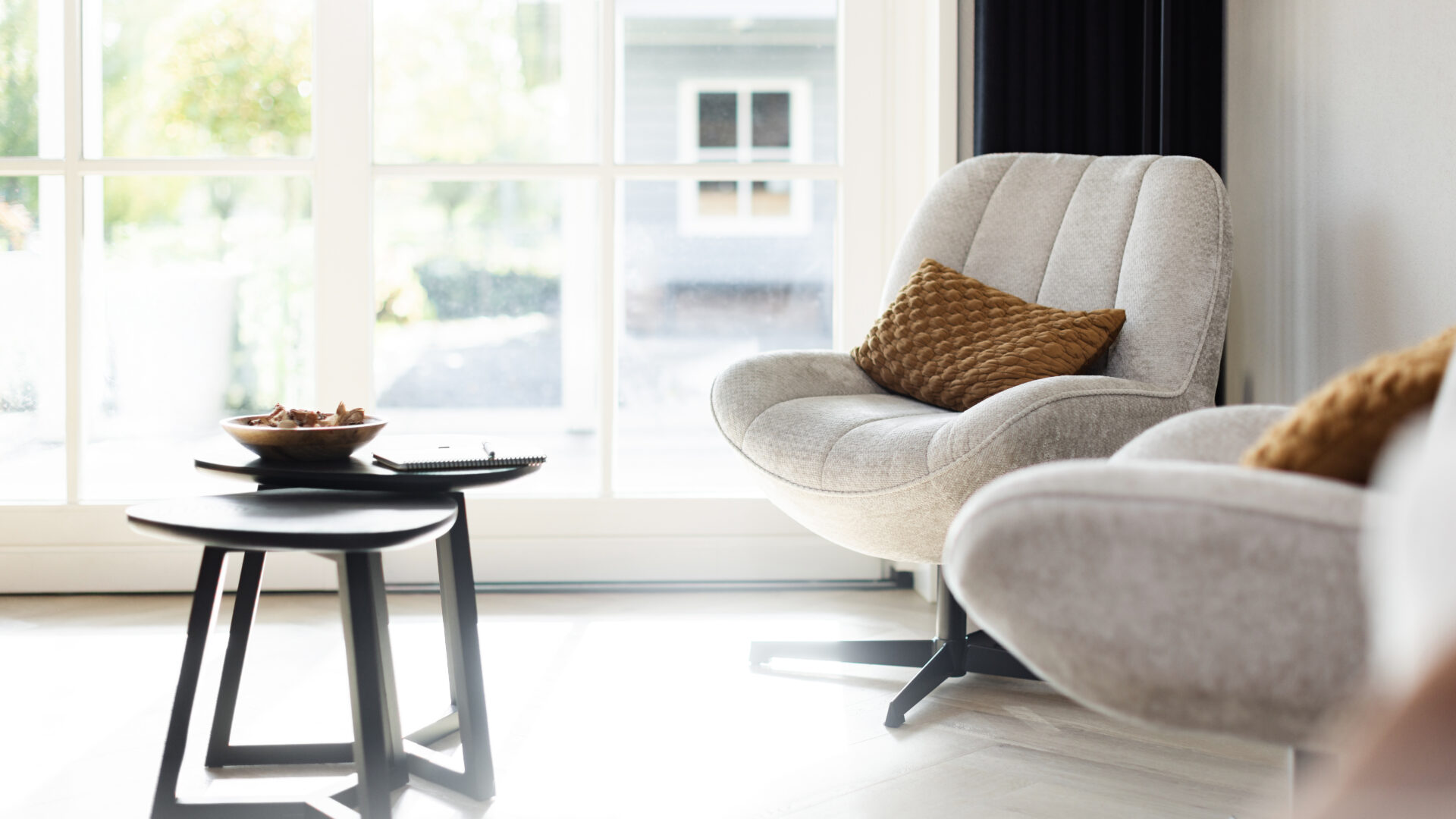 Lichte coachingruimte met comfortabele fauteuils, bijzettafel en rustgevende inrichting.