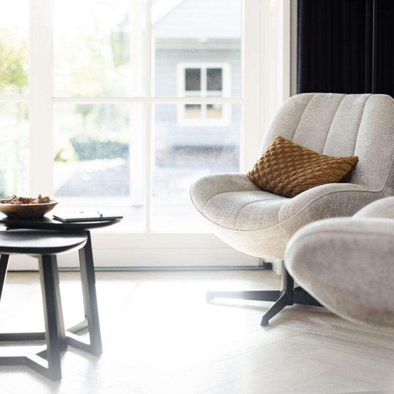 Lichte coachingruimte met comfortabele fauteuils, bijzettafel en rustgevende inrichting.